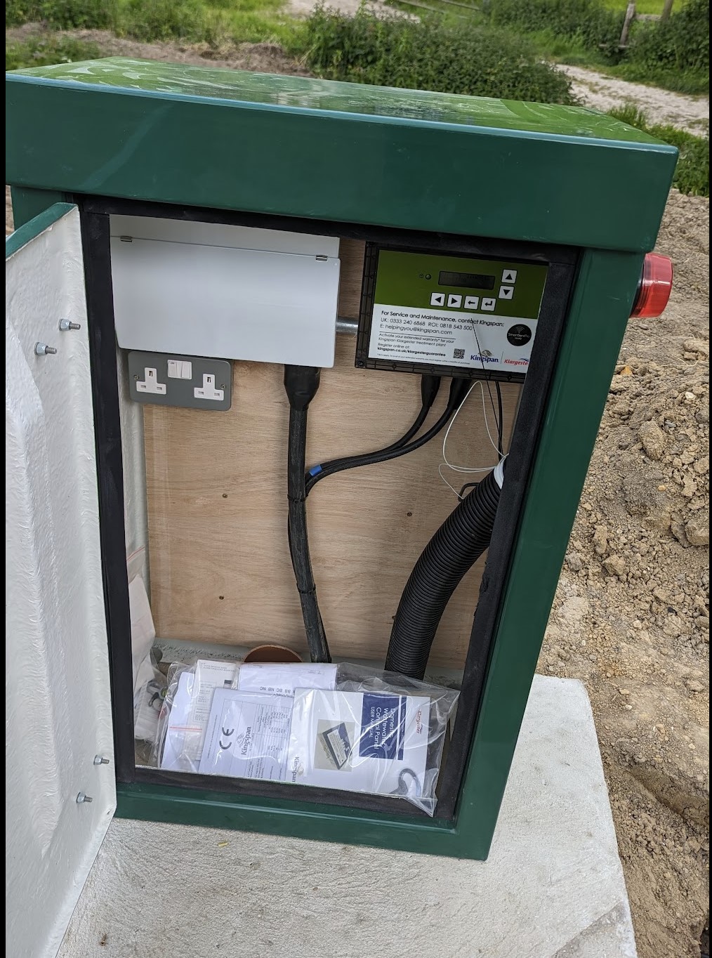 The open control cabinet showing the BioDisc controller, power socket and red alarm beacon.